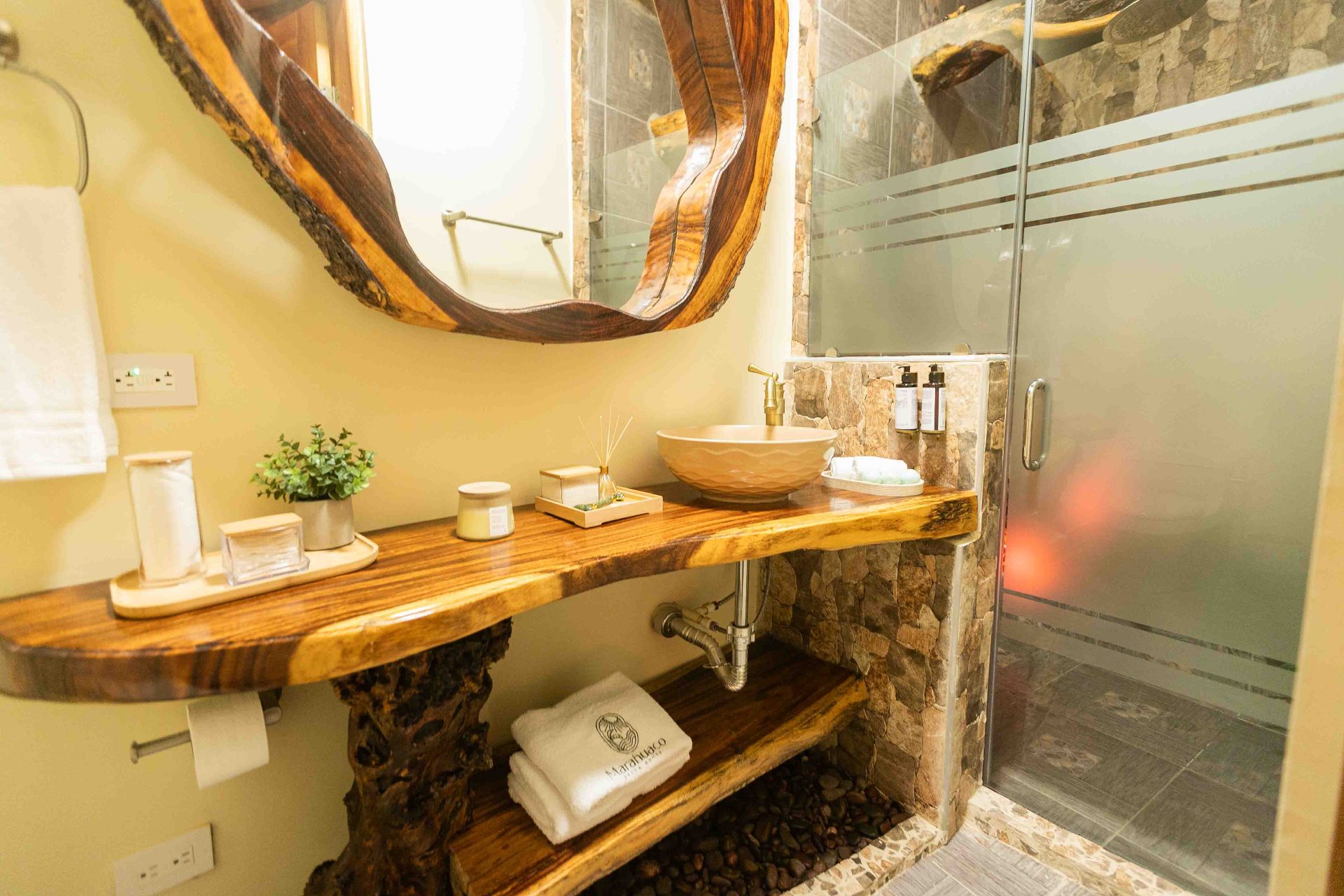 Detalle del baño con vanidad en madera y piedra natural