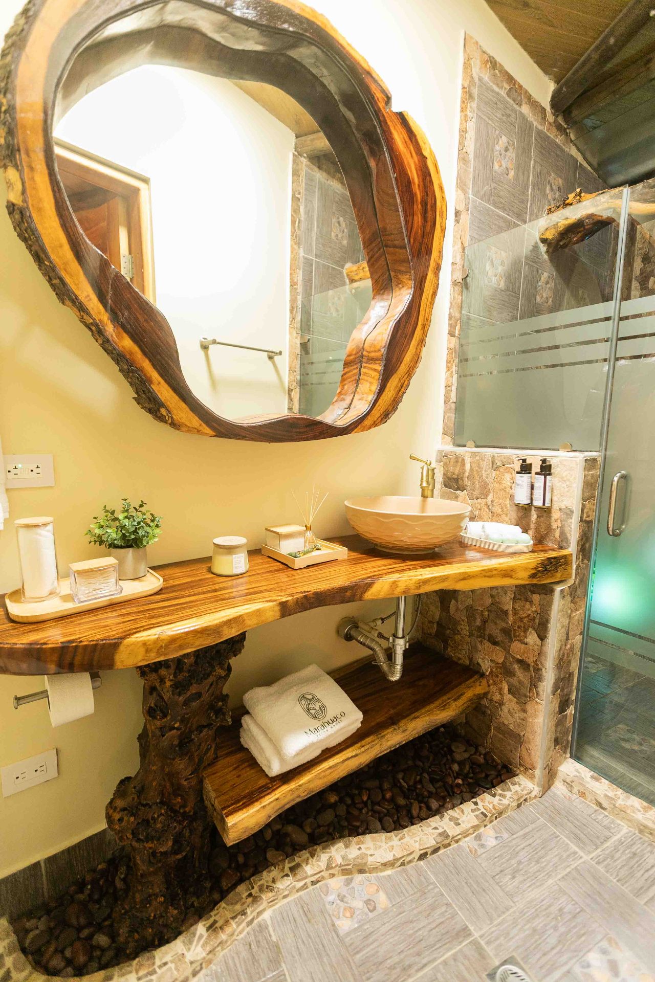 Artisan bathroom with wooden vanity and hand-carved mirror at Marahuaco Beach House