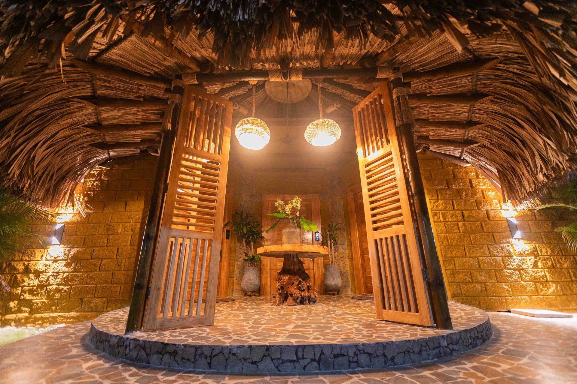 Lobby tropical iluminado con lámparas artesanales